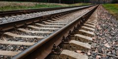 Local railway with the asphalt road crossing in a countryside.