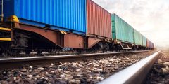 Train wagons carrying cargo containers for shipping companies.